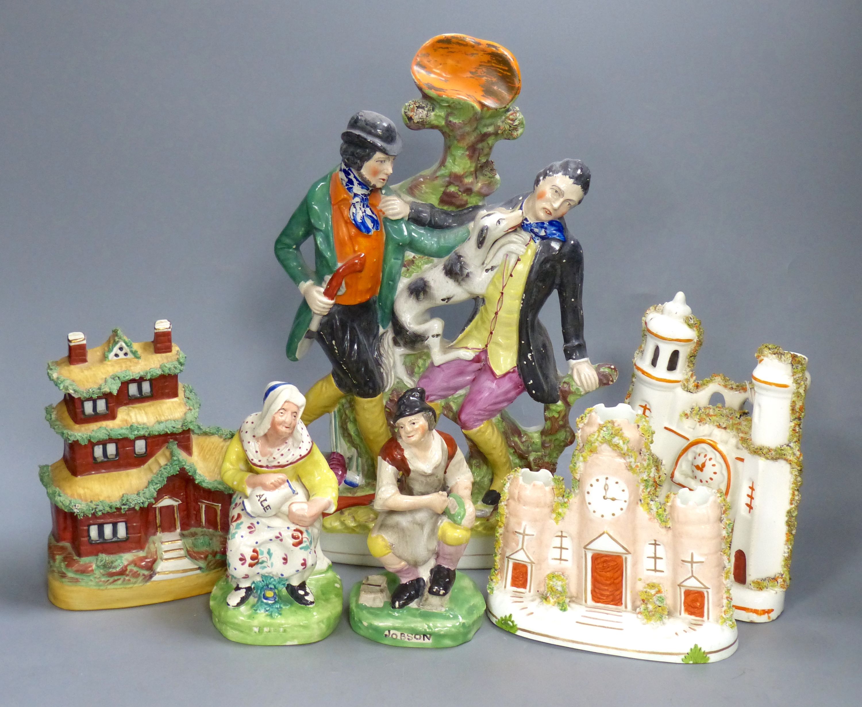 A pair of 19th century Staffordshire figures, 'Jobson' and 'Nellie', two castle flatback groups, a cottage pastille burner and a Gamekeeper and Poacher spill vase (6)